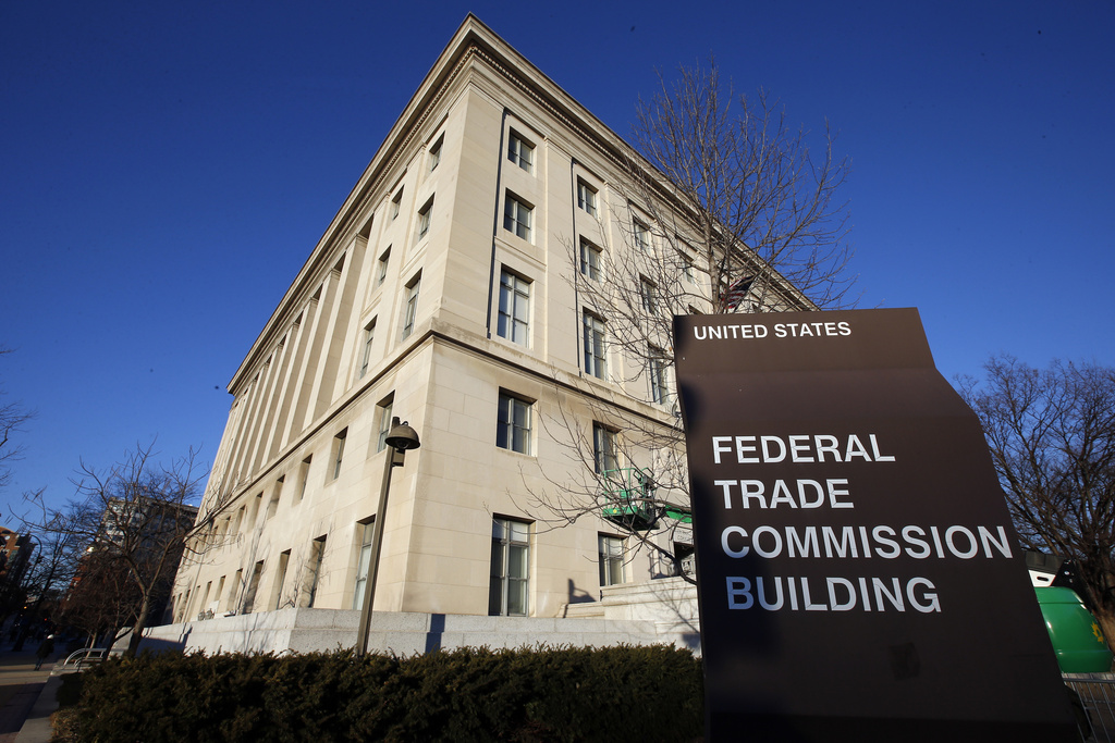 A tan building in the foreground with a sign that says "Federal Trade Commission Building."