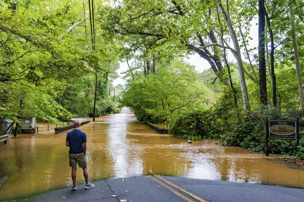 Man looks into flooded river in Atlanta, Georgia