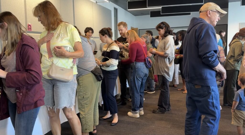 People line up around tables to select their bowls.