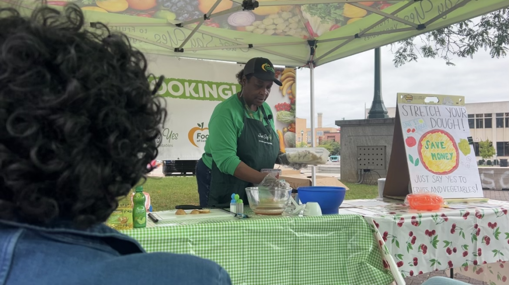 A Food Bank of Central New York program volunteer preparing food for a presentation.