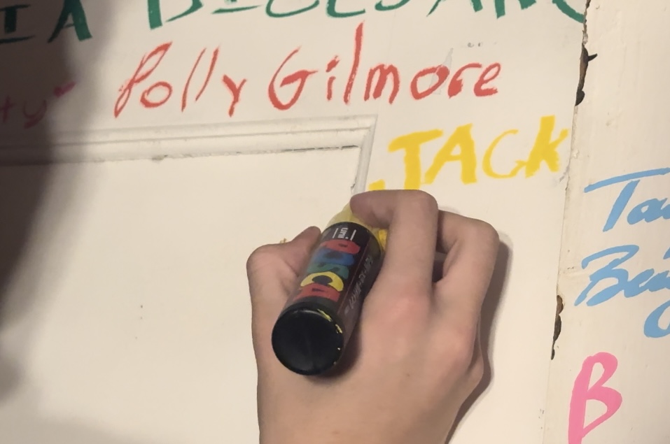 Jack Barsh signing his name on The Playground doors in yellow. 