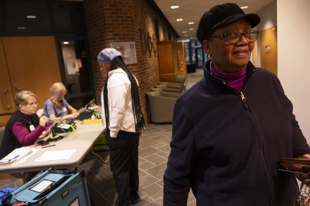 Woman leaves polling place with registration table in background.