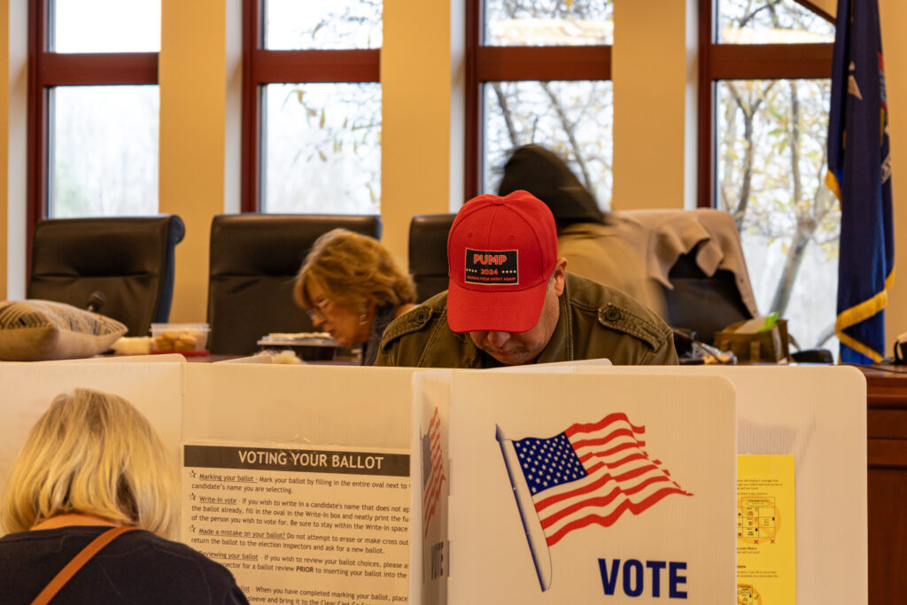 Man fills out ballot in voting booth