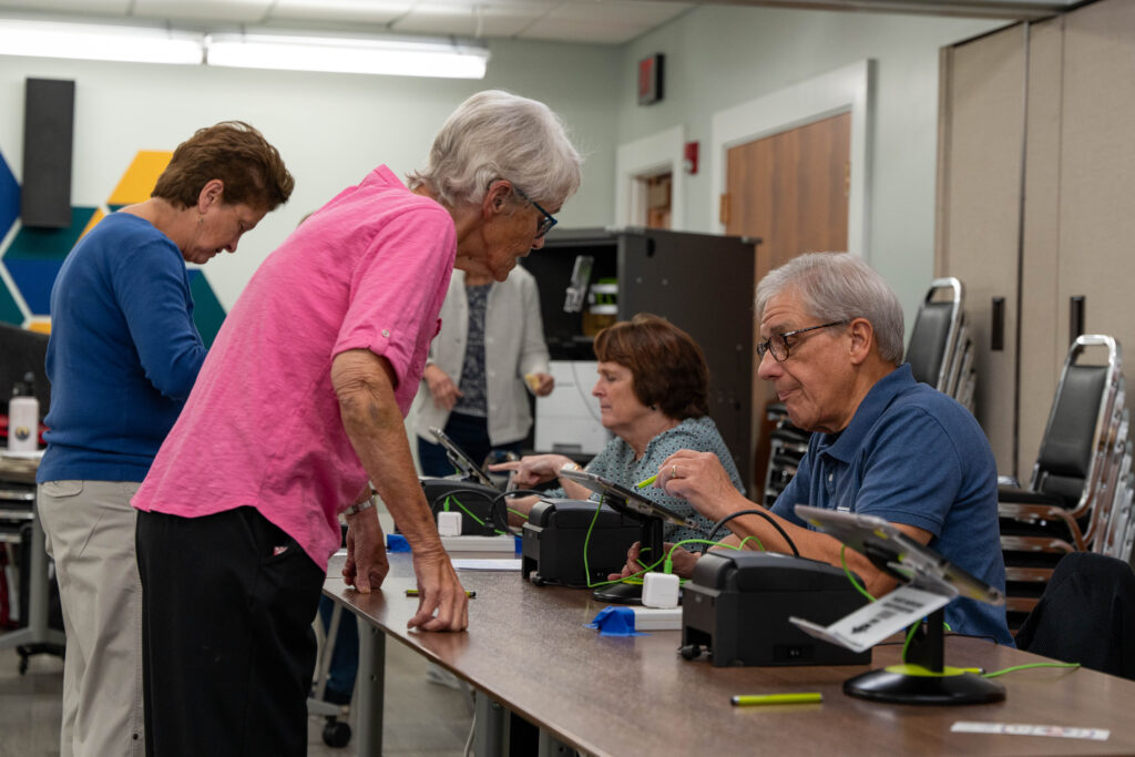 Woman checks in at registration table.