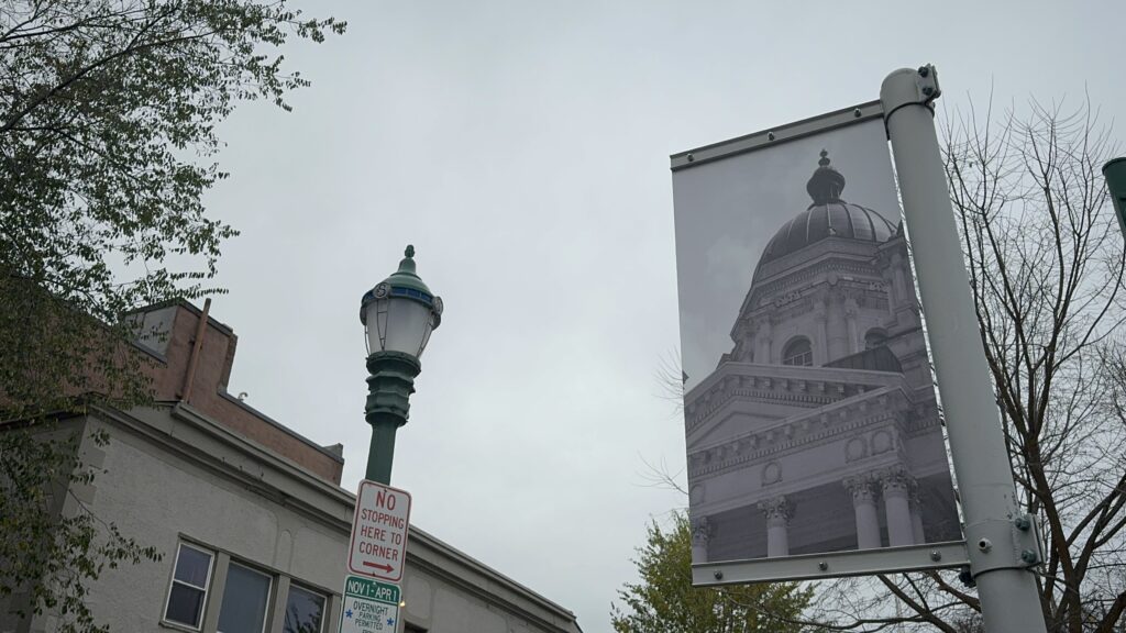 Image of a sign on the street that shows a picture of government building