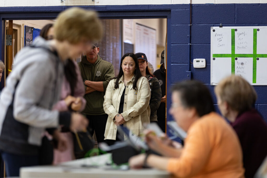 As Election Day arrives, voters head to the polls on Tuesday, they wait in line at the entrance of the polling place, to let their voices be heard in the presidential election.