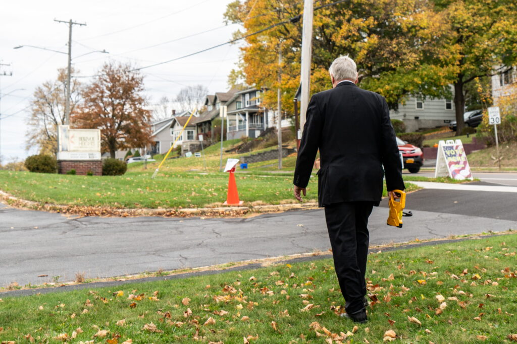 Raymond Dague walks to a traffic cone, which represents the boundary which people can campaign. 