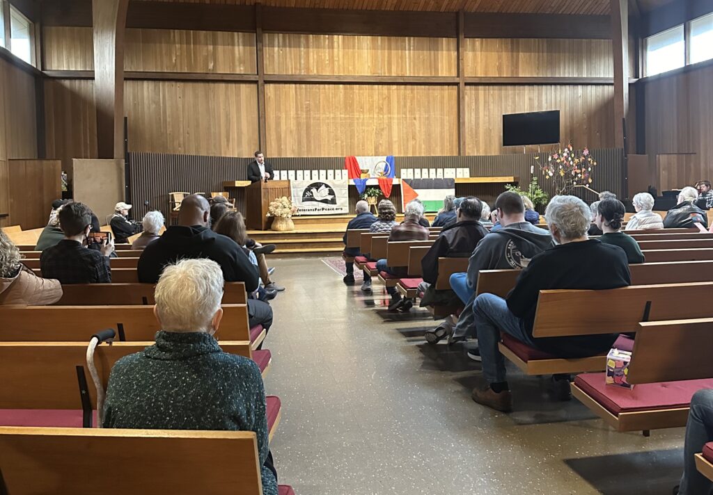 Peace activist speaks to crowd about what Central New Yorkers can do to help bring peace to the Middle East to the audience at Armistice Day event.