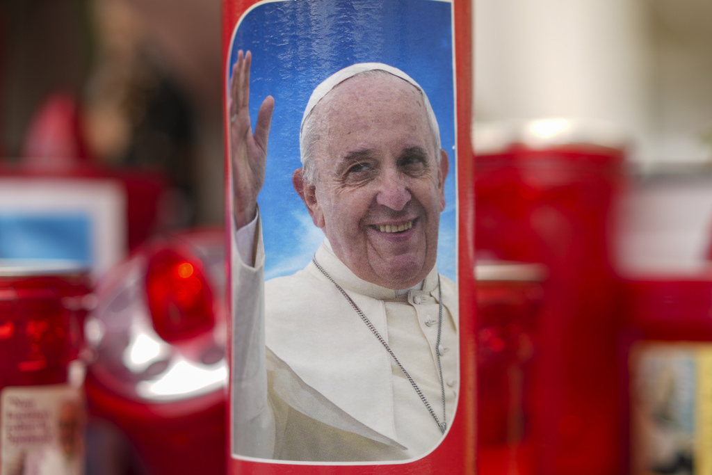 Candles, one showing a photo of Pope Francis, are seen in front of the Agostino Gemelli Polyclinic in Rome, Friday, Feb. 14, 2025, where Pope Francis has been hospitalized to undergo some necessary diagnostic tests and to continue his ongoing treatment for bronchitis. (AP Photo/Andrew Medichini)