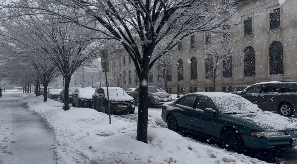 Cars driving across West Genesee Street.