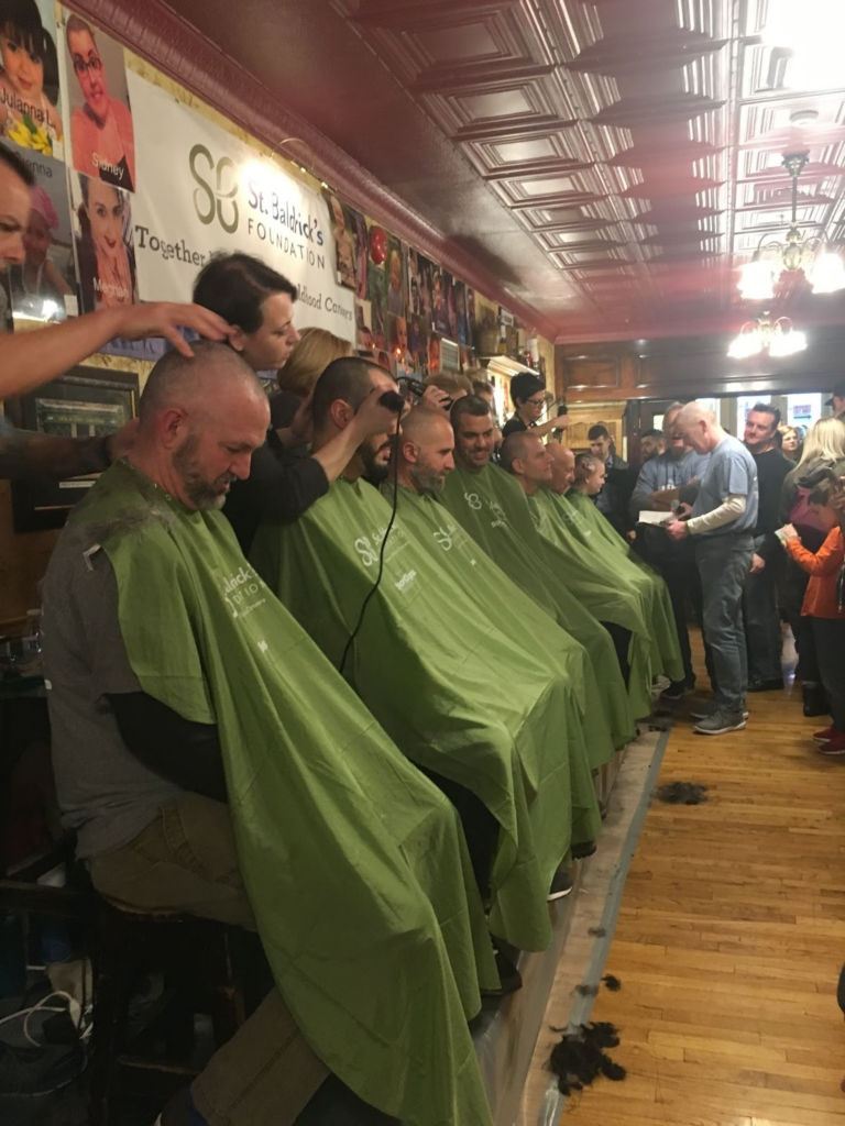 A group participating in the head-shaving event in a past year 