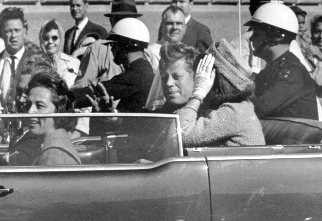 A picture of John F. Kennedy and his wife riding in a car during his motorcade in Dallas, TX. This was moments before his death.