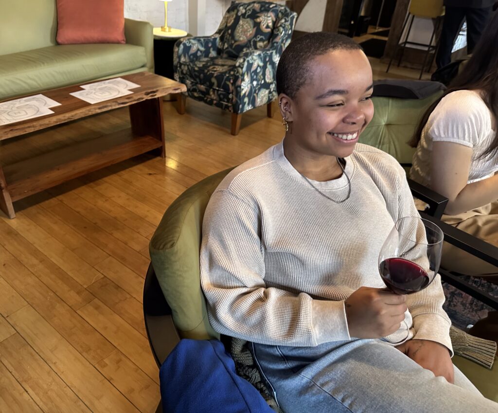 A customer smiling and holding Burgundy wine.