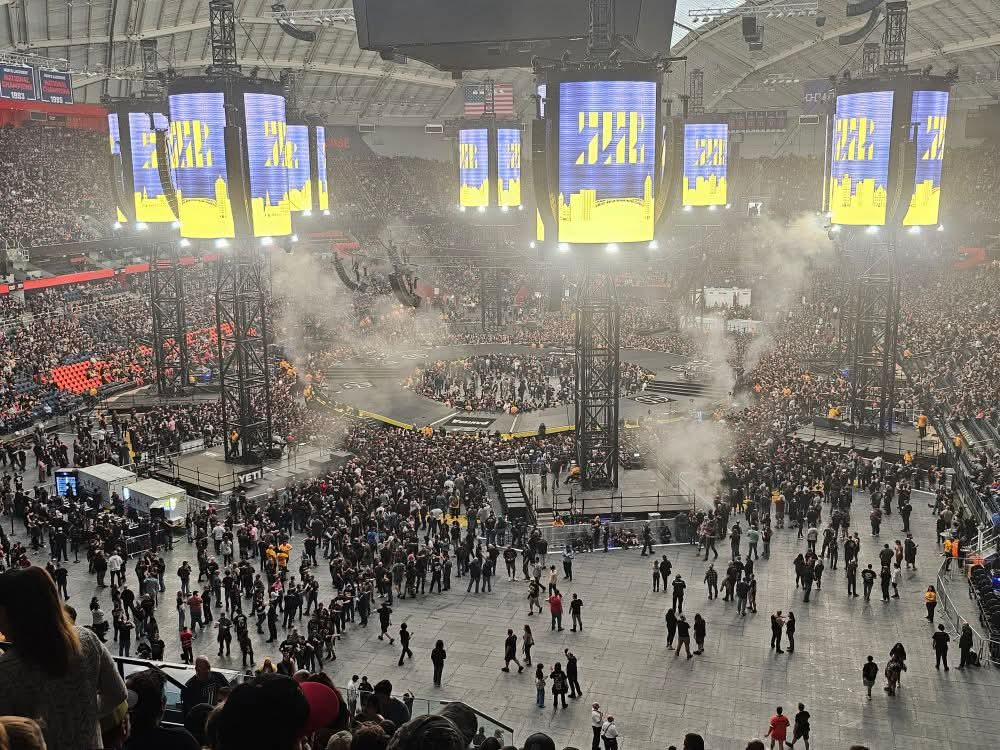 Fans file into a crowded arena before heavy metal concert.