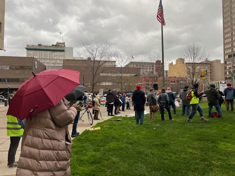 Protesters looking on as different people talk