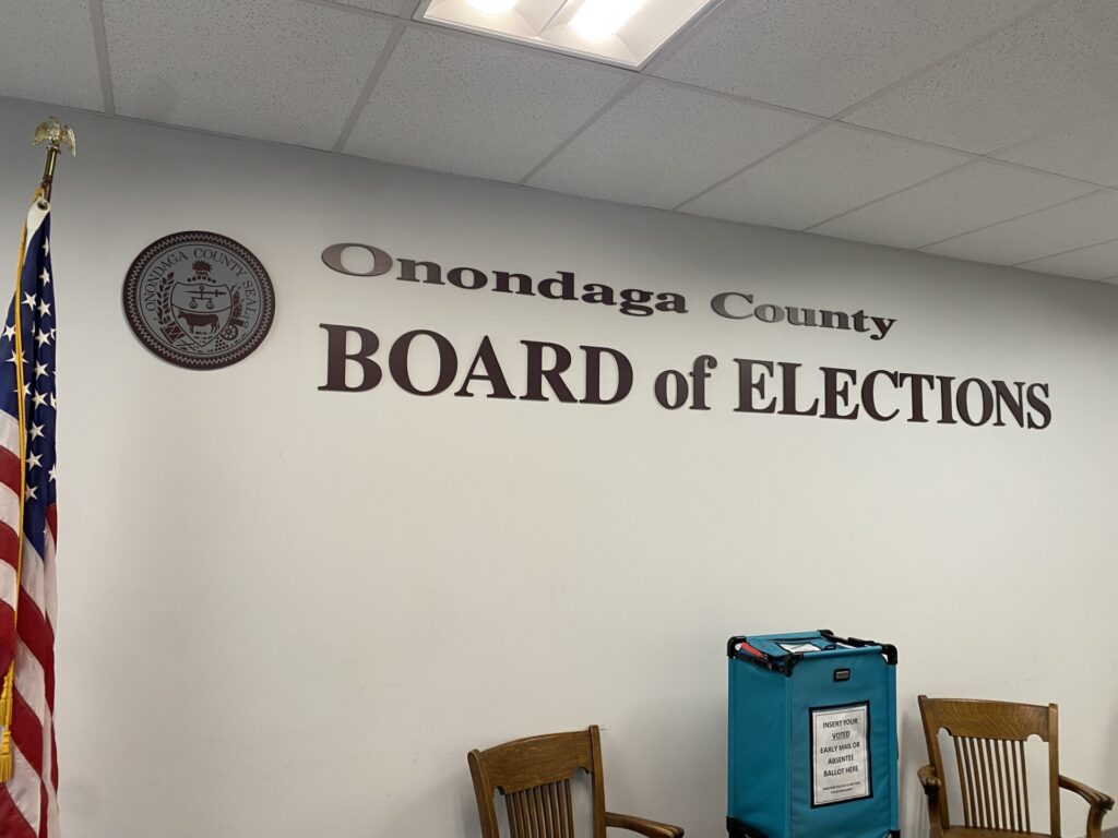 A wall inside the Board of Elections. The letters on the wall say Onondaga County Board of Elections.