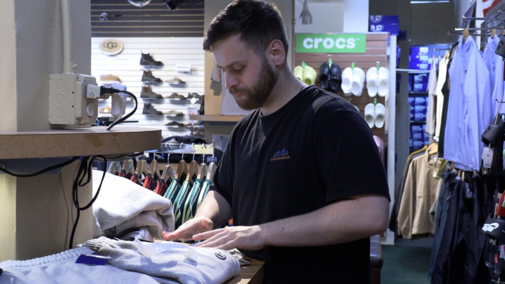 Colin Smith, who is the manager at J. Michael Shoes is packing an online order before it is sent out to a customer. 