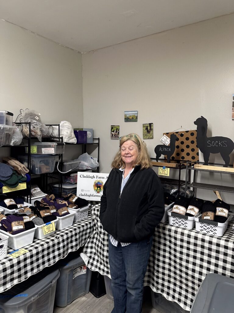 Owner Sarah Lamanna standing around her alpaca products.