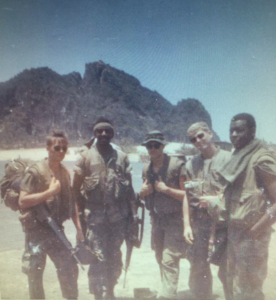 Dennis Buschle and other Vietnam soldiers wait for a helicopter to transport them to a new unit during the Vietnam War. © 1968 Dennis Buschle