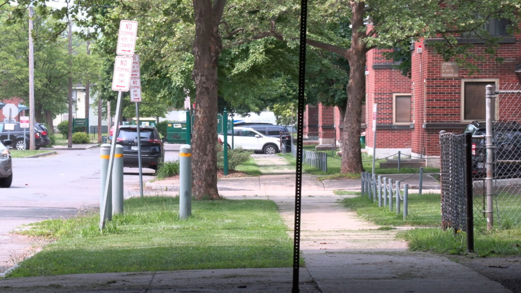 A Syracuse housing development just off Almond Street with sidewalks and brick buildings.