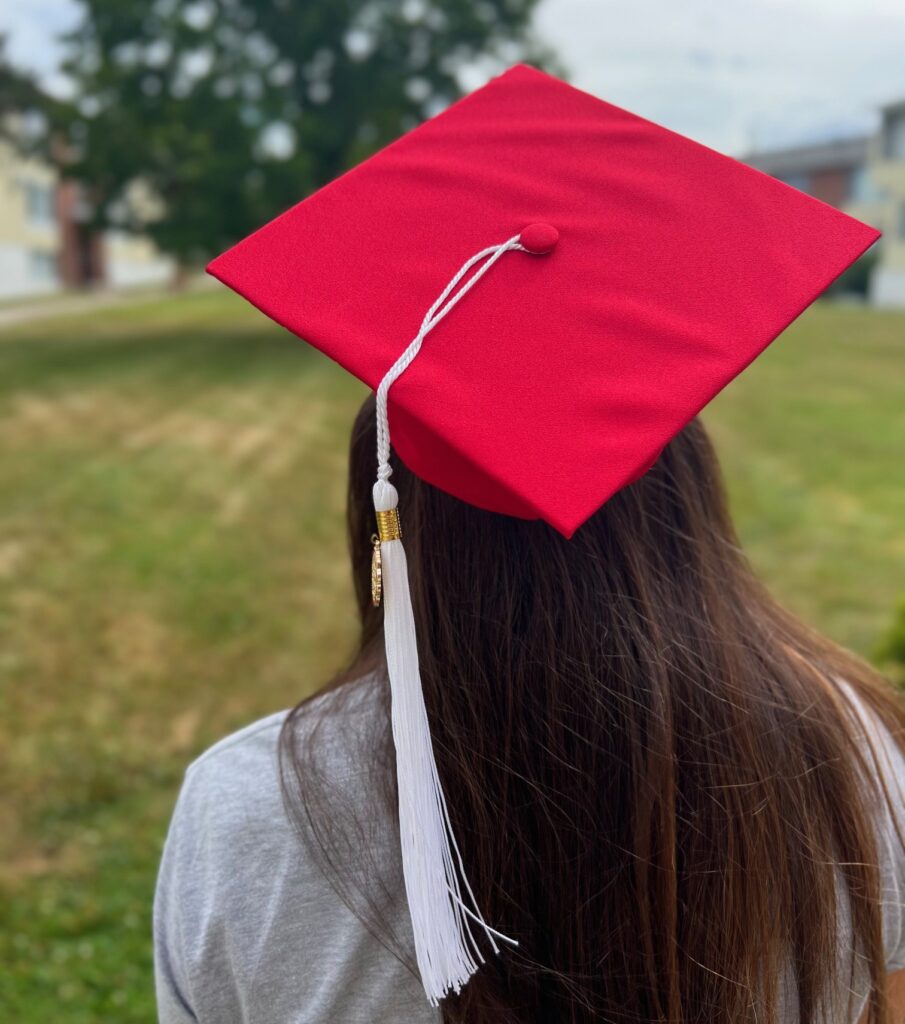 Student poses wearing a graduation cap facing away from the camera to emphasize looking into the future.