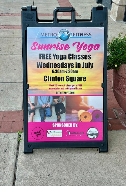 A sidewalk sign advertising free Sunrise Yoga classes.