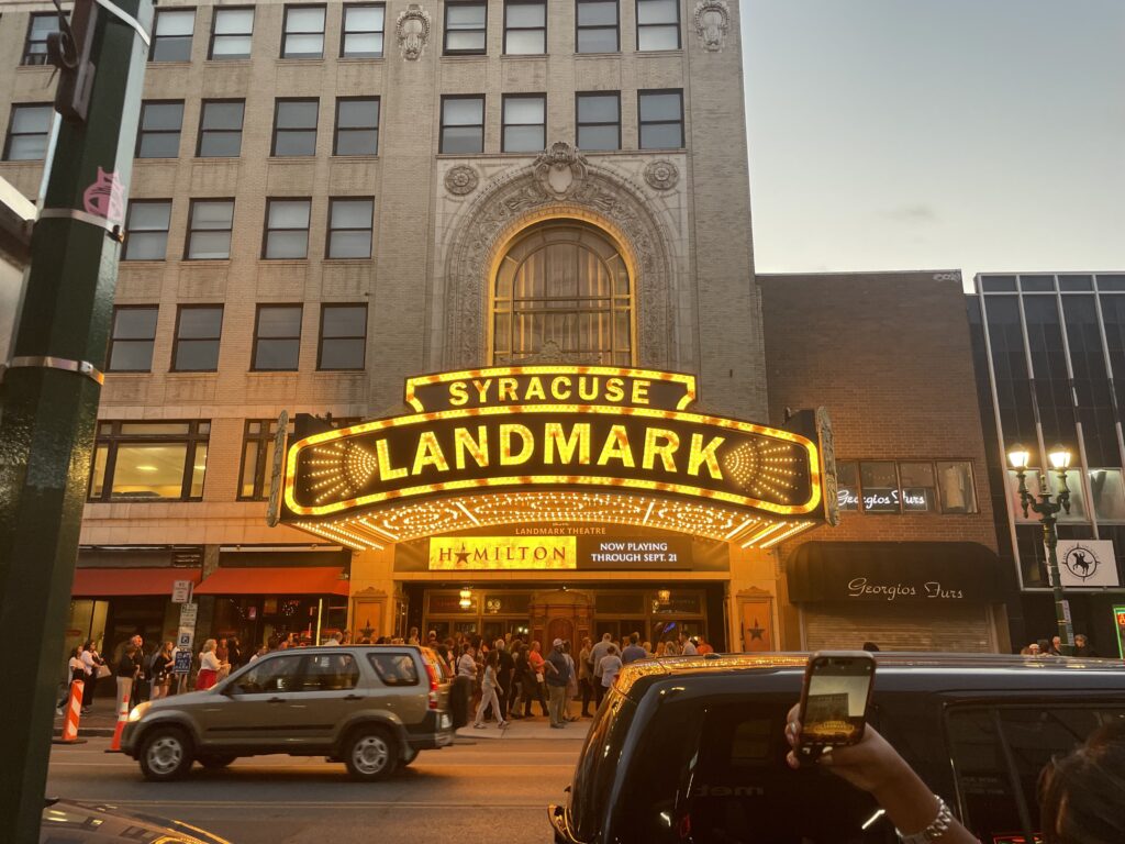 The lit up marquee outside of the Landmark Theatre displaying Hamilton.