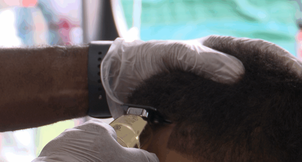Barber using a trimmer for a boy's haircut.
