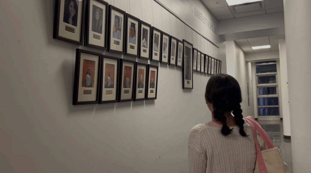 student looking at photos on wall