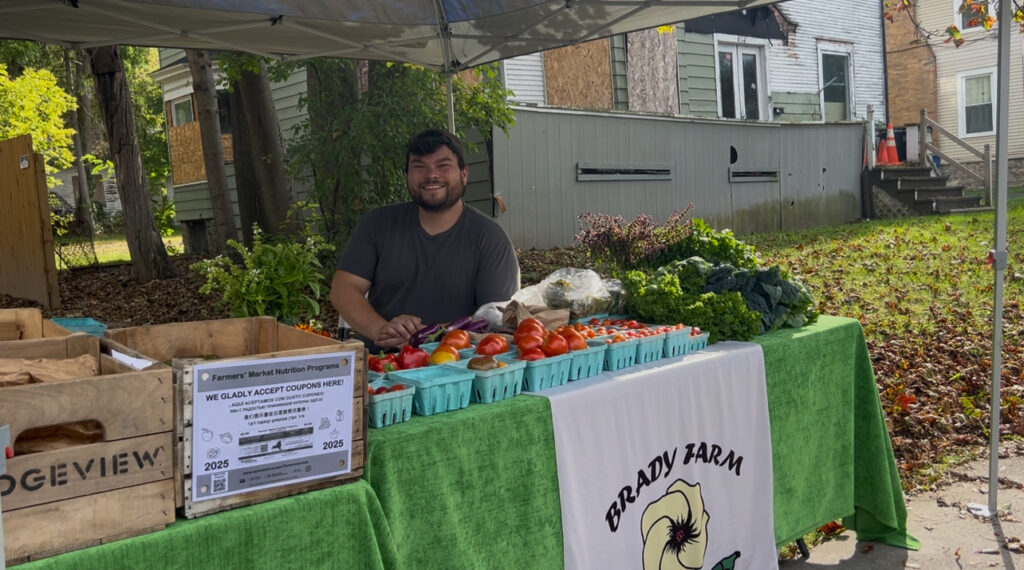 Man at farm stand with vegetables