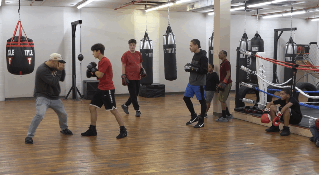 Syracuse Boxing Coach Joe Stray in the middle of a punch during class. 