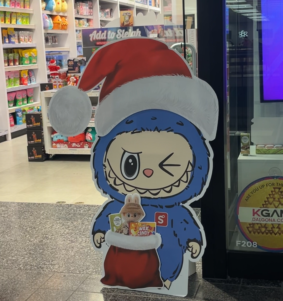 Showcase's storefront featuring a cardbord, blue Labubu wearing a Santa hat.