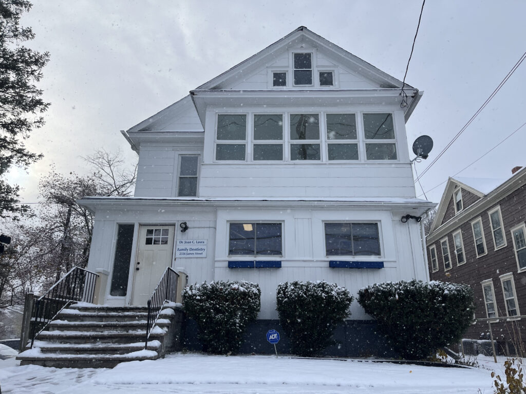 White dentist office sits on James Street on a snowy day.