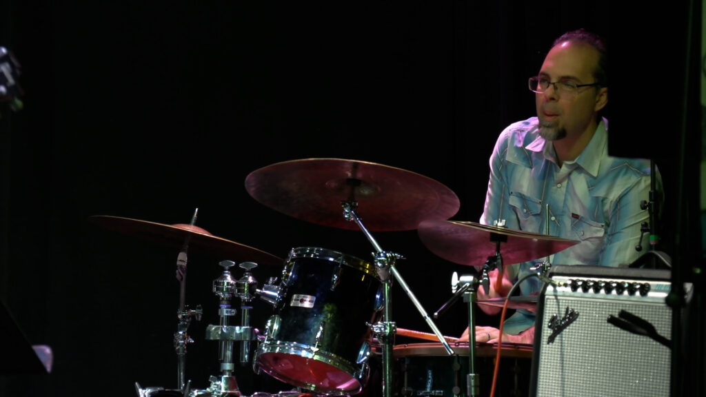 Josh Dekaney playing the drums on the stage at the Jazz Jam at Funk N' Waffles © Augie Walters