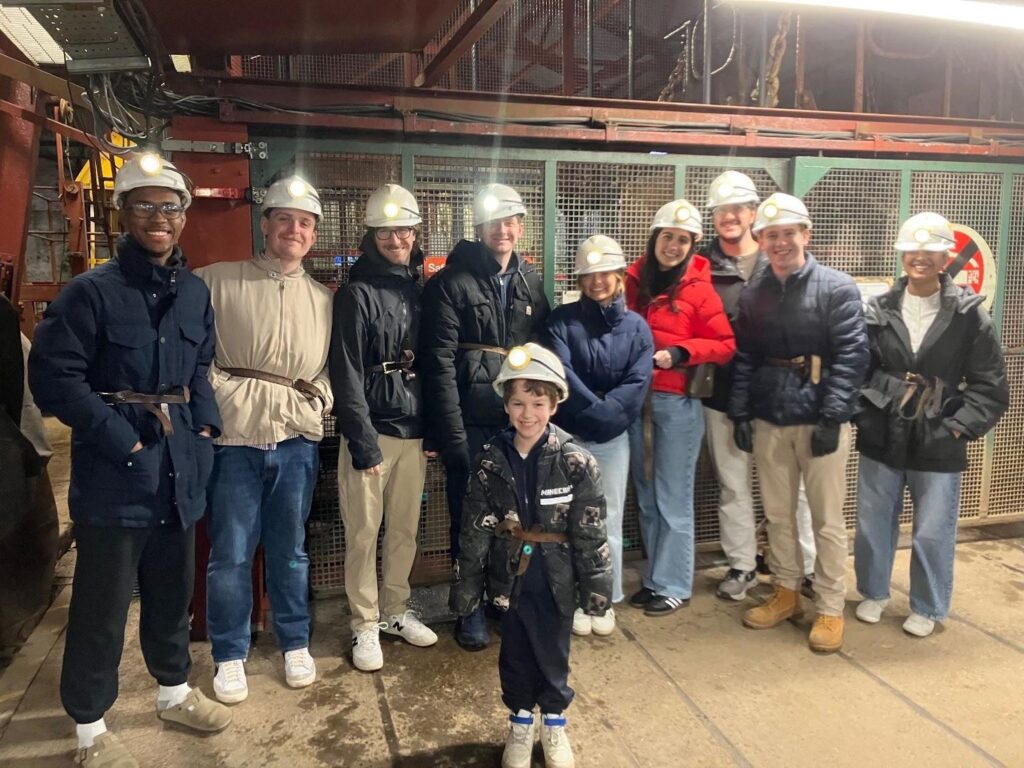 A group of study abroad students pose in a coal mine in Wales. 