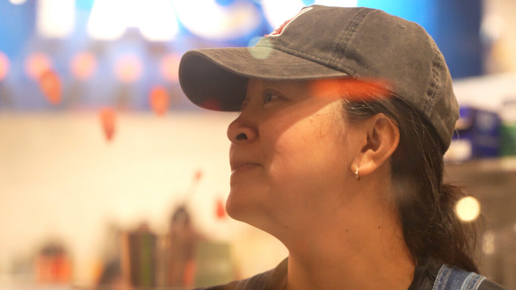 Woman in gray hat looking off to the side and smiling.