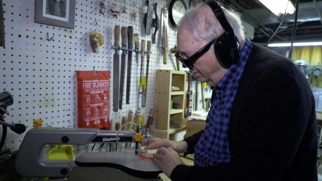 man uses power tool to cut off wood