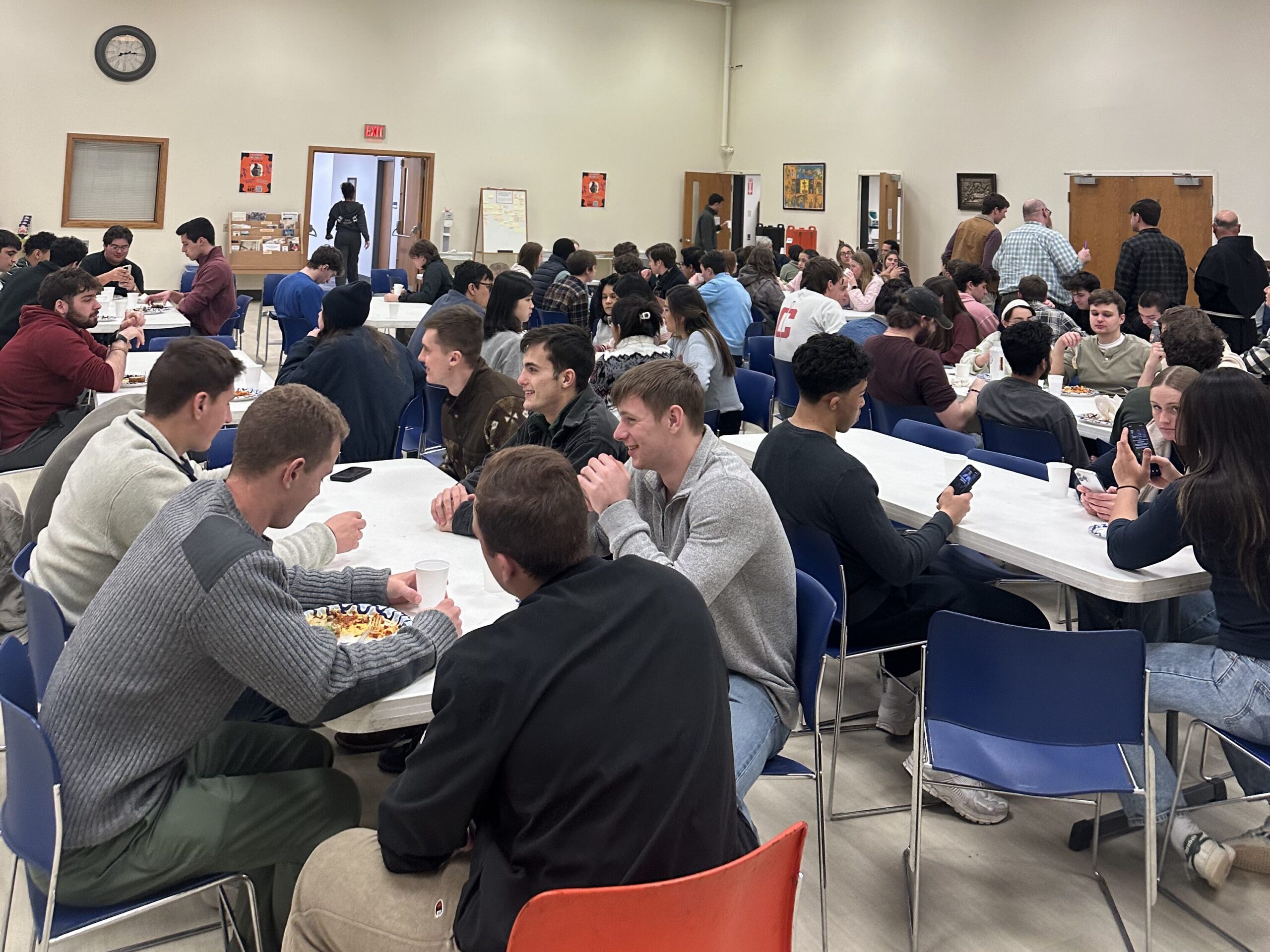 Members of the Catholic Center community fill the dining hall seats and enjoy a meal with one another.