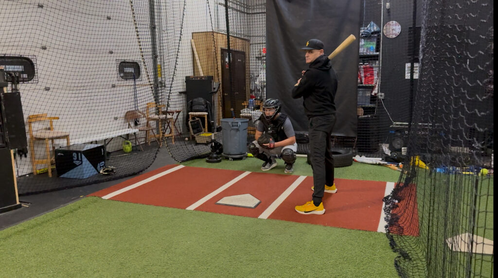 Owner Dan Almonte standing in on a catching lesson. © Joey Cicini. 2026