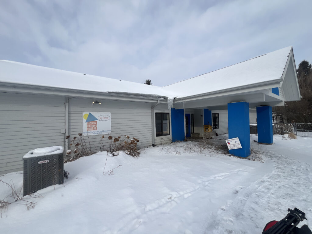 The white building with blue legs is the Cazenovia Children's House.