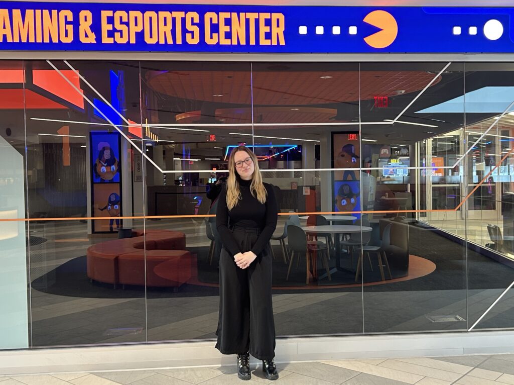 Student Lead Bri Nechifor stands by the exterior of the Gaming & Esports Center.