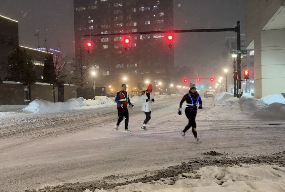 Club members run through a harsh snowstorm in downtown Syracuse