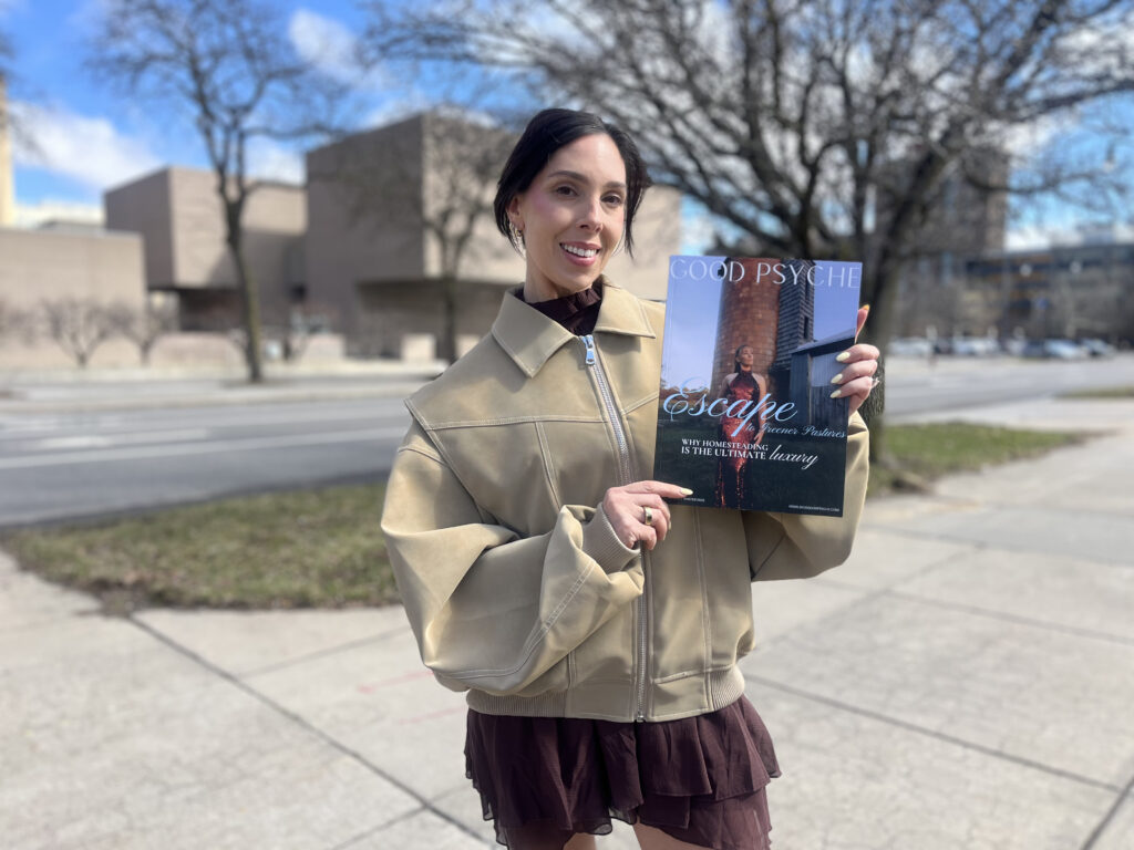 Woman in beige jacket shows her magazine and one of the reasons she came to connect at the event.