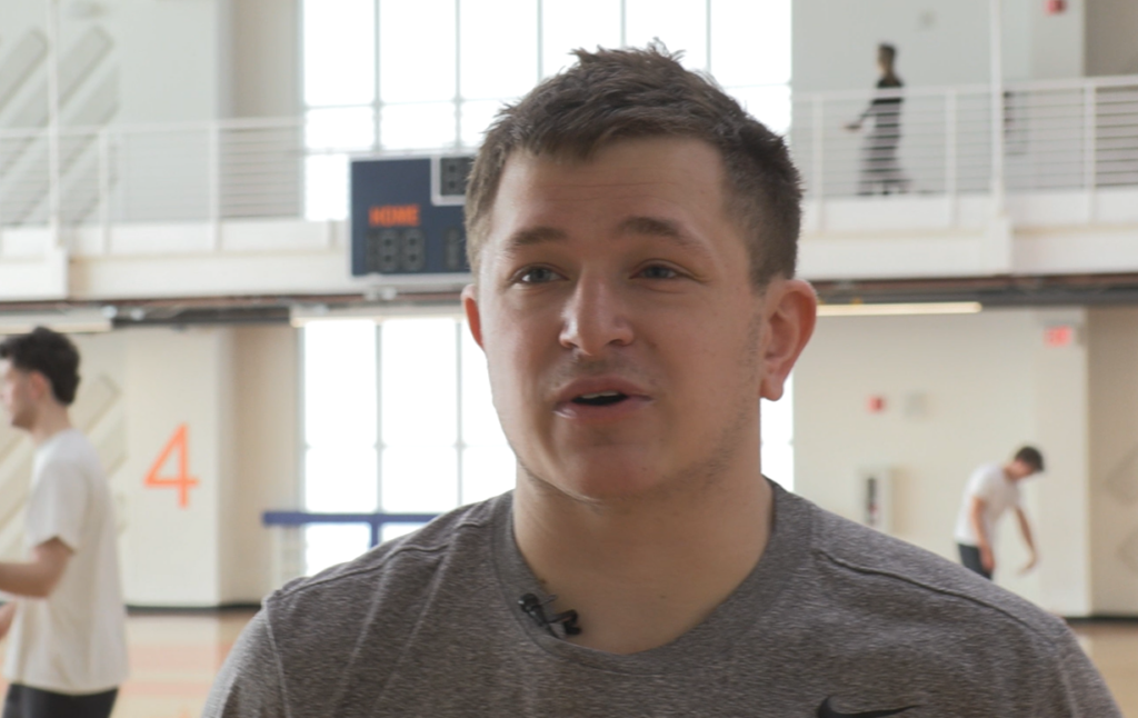 David Bulan standing in front of an active gym at the Barnes Center.
