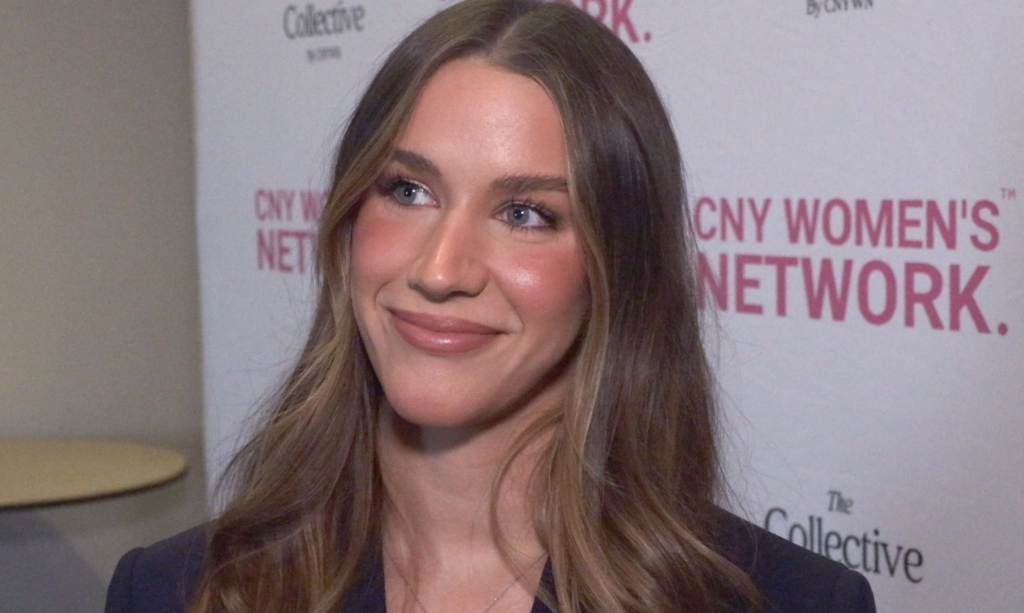 Alex Canavan answers questions in front of white backdrop.