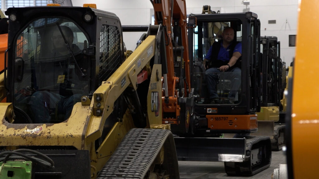 A row of heavy machinery parades down the aisle of Syracuse's Hard Hat Expo