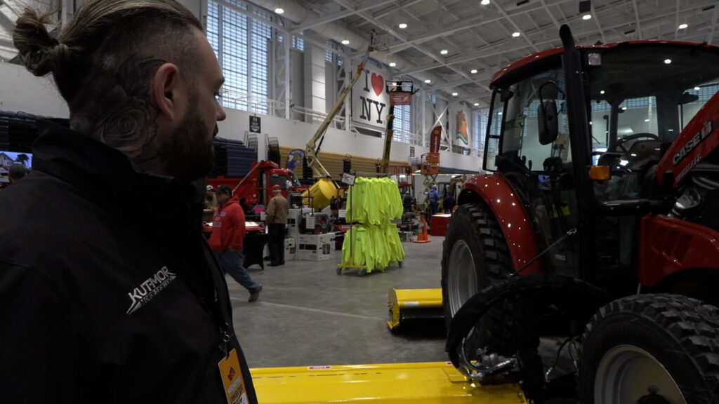 A man looks at a tractor at Syracuse's Hard Hat Expo