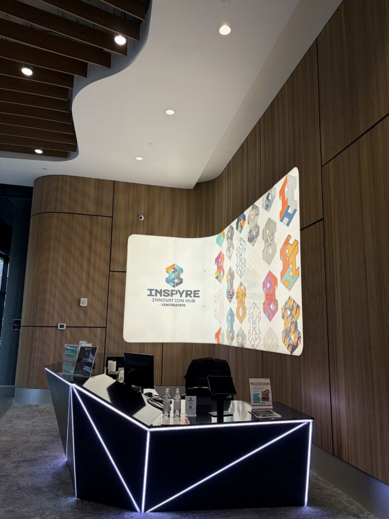 This photo showcases the front desk and wall design in the Inspyre Innovation Hub.