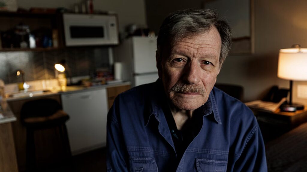 Old Man sadly looks into camera