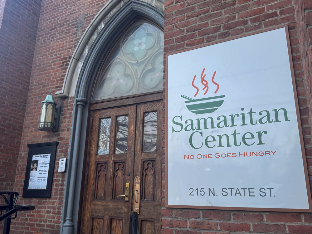The exterior of the Samaritan Center in Syracuse, New York, showing a sign reading "No One Goes Hungry" 